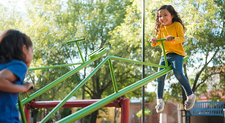 Happy little girls on a teeter totter